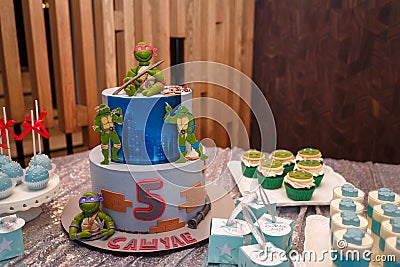 Festive candy bar for 5 years old boy birthday party. Blue cakepops, cupcakes. Sweet Cake Teenage Mutant Ninja Turtles Editorial Stock Photo