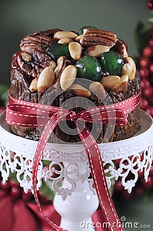 Festive Christmas food, fruit cake with glace cherries and nuts on white cake stand Stock Photo