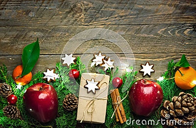 Festive colorful botanical Christmas composition. Fresh green juniper red apples pine cones baubles gift boxes in craft paper Stock Photo