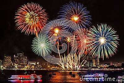 Festive colorful firework light up the sky over the city at nigh Stock Photo