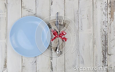 Festive composition with empty blue plate and cutlery set on rustic white wooden table. Table settings. Top view Stock Photo