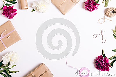 Festive composition of peonies and gifts on a white table Stock Photo