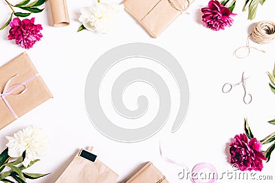 Festive composition on white background: peonies flowers, gifts, ribbons, wrapping paper Stock Photo