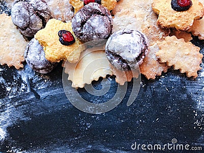 Festive cookies on a black kitchen board with powdered sugar Stock Photo