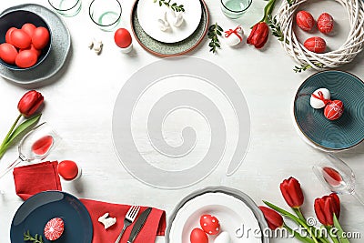 Festive Easter table setting with painted eggs on wooden background, top view Stock Photo