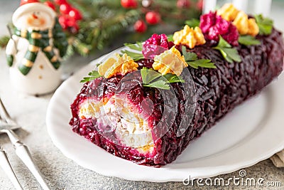 Festive layered shuba salad. Traditional Russian Christmas New Year vegetable salad roll with herring and boiled vegetables Stock Photo