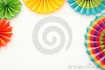 Festive and party background with colorful paper circle fans over wooden white background. Copy space. Stock Photo