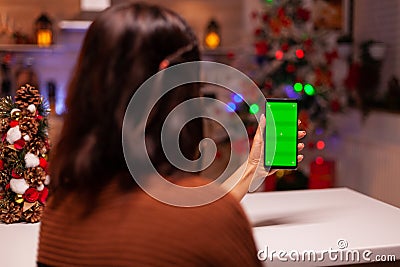 Festive person holding smartphone with green screen Stock Photo