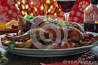 Festive roast duck on wooden table with baked potatoes, apples a Stock Photo