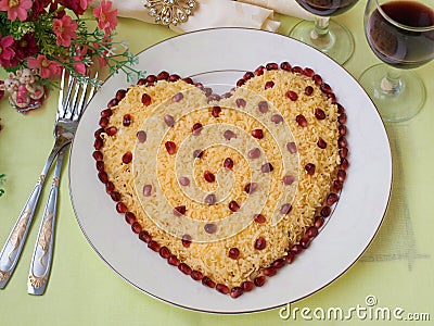 Festive salad in the shape of a heart, decorated with pomegranate seeds, the idea of decoration for Valentine`s Day, Horizontal Stock Photo