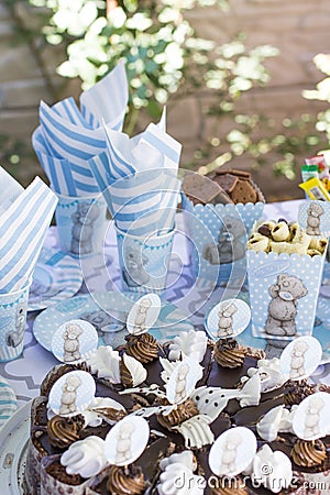 Festive table setting for children. Decoration for children`s party. Teddy bear style serving. Cake, parcels, cookies, cups, plate Stock Photo