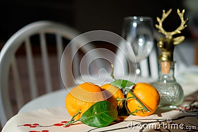 Festive table setting with Tangerines with leaves. Tableware and New Year`s decor Stock Photo