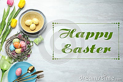 Festive table setting and text Happy Easter on wooden background Stock Photo