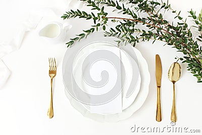 Festive wedding, birthday table setting with golden cutlery, eucalyptus parvifolia branch, porcelain plate, milk and Stock Photo