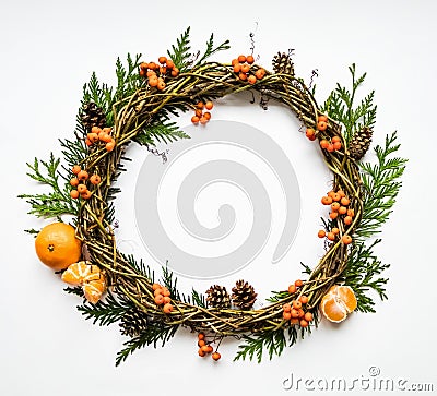 Festive wreath of vines with tangerines, thuja branches, rowanberries and cones. Flat lay, top view Stock Photo