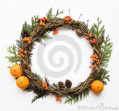 Festive wreath of vines with tangerines, thuja branches, rowanberries and cones. Flat lay, top view Stock Photo