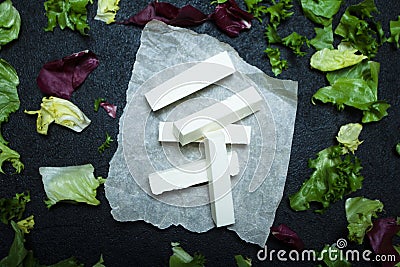 Feta cheese sticks, lettuce leaves on a black background Stock Photo