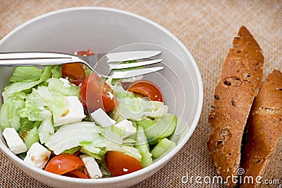 Fetta salad portion and slices of whole wheat bread Stock Photo
