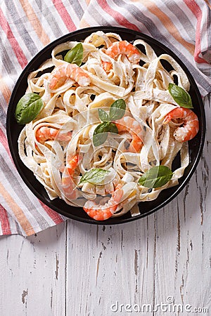 Fettuccini pasta in cream sauce with shrimp on a plate. vertical Stock Photo