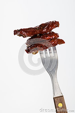 Few dried tomatoes impaled on fork Stock Photo
