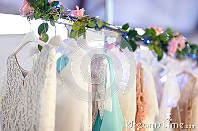 Few elegant wedding, bridesmaid ,evening, ball gown or prom dresses on a hanger in a bridal shop Stock Photo