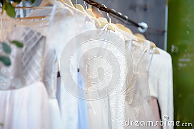 Few elegant wedding, bridesmaid ,evening, ball gown or prom dresses on a hanger in a bridal shop Stock Photo