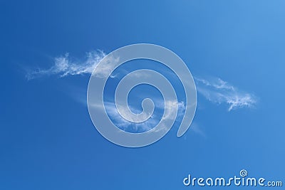 A few feathery clouds fly in the clear blue sky. Stock Photo
