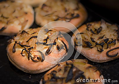 A few onion breads baking in the oven. The light is sharp and coming from above. Stock Photo