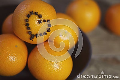 A few oranges with a heart aign made of close seeds in a gray bowl closeup on an old wooden backdround in brown with a blurred bac Stock Photo