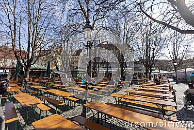 Few People in a german Biergarten Outdoor Beer Pub at the Viktualienmarkt Victuals Market in Munich during the first wave Editorial Stock Photo