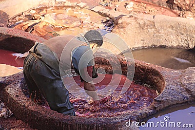 Fez, Morocco - January 01, 2010: Workers are dyeing and tanning leather at the tannery in Fez using the traditional Editorial Stock Photo