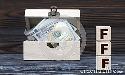 FFF - acronym on cubes against the background of a chest of money Stock Photo