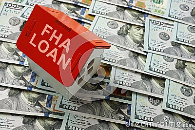 FHA loan concept. The house model stands on cash. Stock Photo