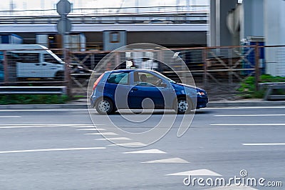 Fiat Punto on the city road in motion. Compact blue hatchback with a man driving. Speeding is not permissible Editorial Stock Photo