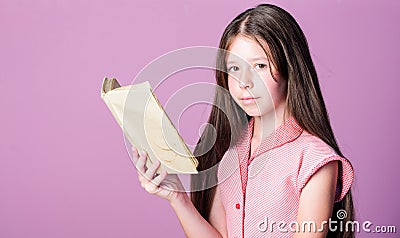 Fiction and nonfiction. Cute small child reading book on violet background. Thirst of knowledge. Adorable bookworm Stock Photo