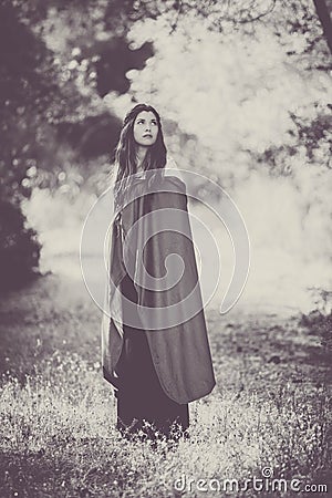 Fiction woman in cloak in forest. Stock Photo