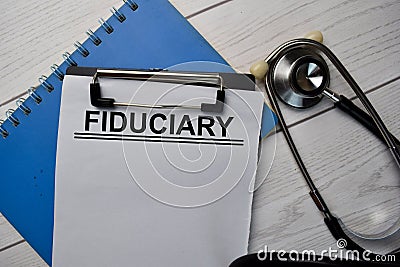 Fiduciary text write on a paperwork and stethoscope isolated on office desk Stock Photo