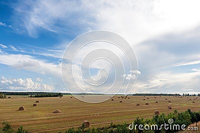 Field and clouds with hay bales Stock Photo