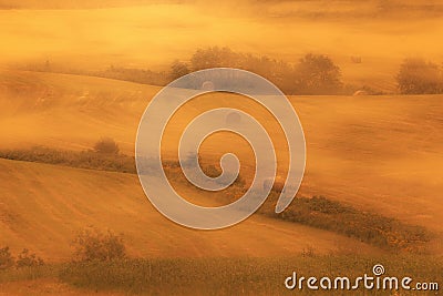 Gold foggy dreamy morning in hay field with stacks Stock Photo