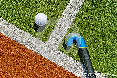 Field hockey stick and ball on brown and green grass Stock Photo