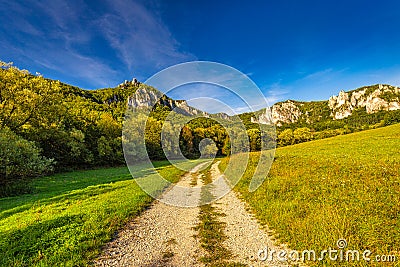 A field road through the valley of mountain landscape with rocky Stock Photo