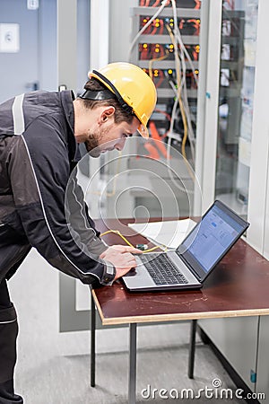 Field service engineer inspect relay protection system with laptop comput Stock Photo