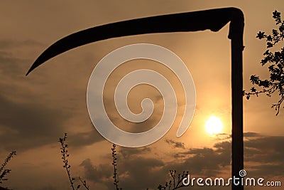 Field sunset and scythe Stock Photo