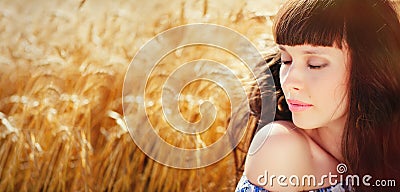 A field of wheat. Beautiful woman Stock Photo