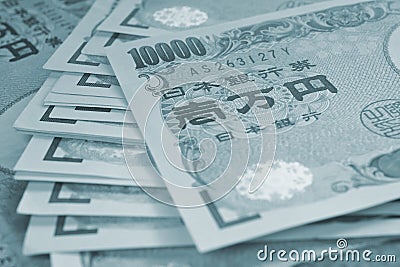 A field of 10000 yen Japanese bills. Tinted gray or grey-blue background with low contrast. A heap of banknotes. Light backdrop on Stock Photo