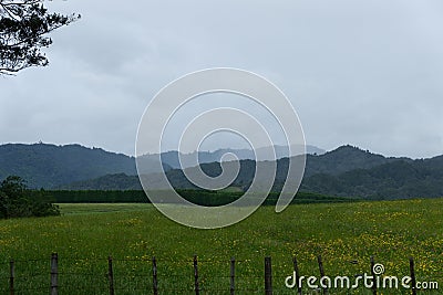 Fields grass farm mountain hills sky clouds fence Stock Photo