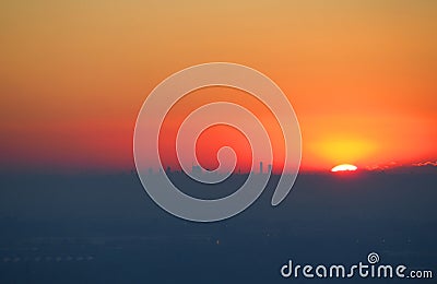 Fiery sunset from the Venetian walls of Bergamo. View of silhouettes of skyscrapers of Milan Stock Photo