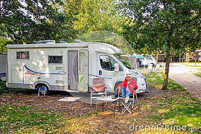 Enjoy a nice autumn sun next to the camper at a campsite. Editorial Stock Photo