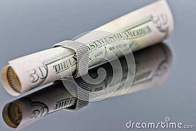 Fifty dollar bill is rolled into elegant women`s silver ring Stock Photo