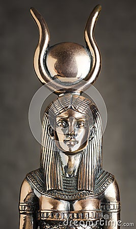 The figure of the Egyptian goddess Isis on a brown corduroy background. Bronze statuette Stock Photo
